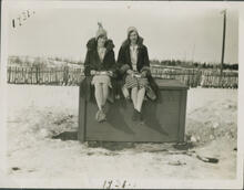 [Two girls sitting on a crate]
