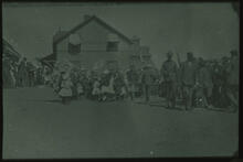 School children and adults on railway station platform with flags and banners