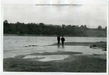 Two men standing on sandbar in South Saskatchewan River