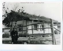 Woman in front of Doukhobor house