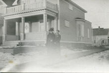 [Women standing in front of a house]