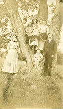 [Image of family posing for a photo by a large tree]