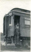 [Man posing in doorway of a rail car]